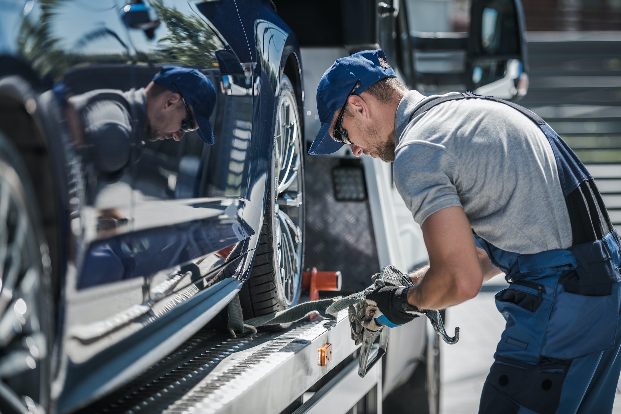 Tow Truck Driver Securing Loaded Car for Safe Delivery