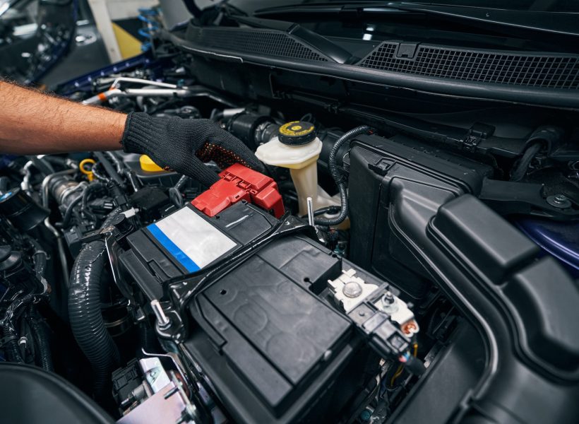 Person checking the car battery under bonnet